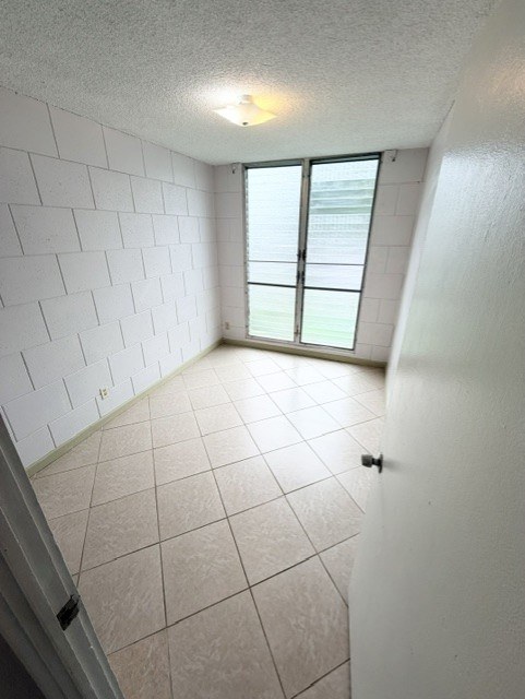 A white tiled room with a window and a door.